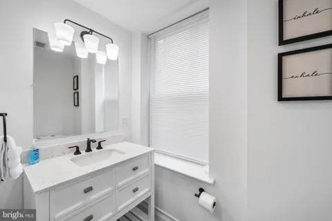 a bathroom with a sink vanity and a mirror