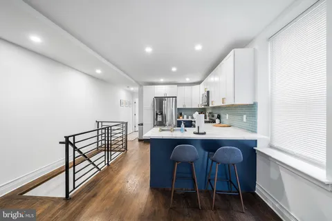 a kitchen with stainless steel appliances a dining table chairs and granite counter tops