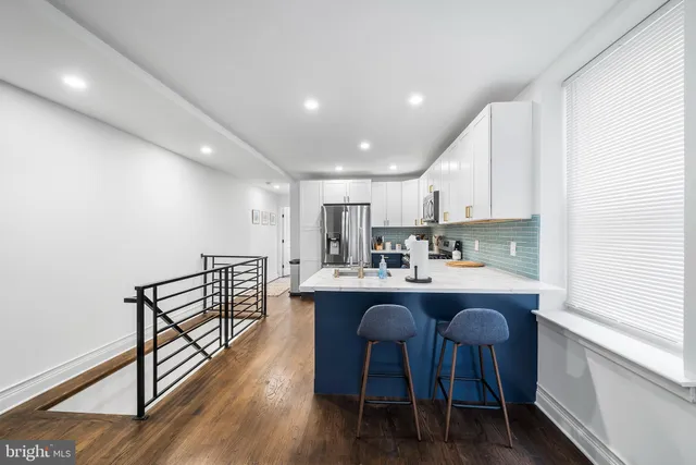 a kitchen with stainless steel appliances a dining table chairs and granite counter tops