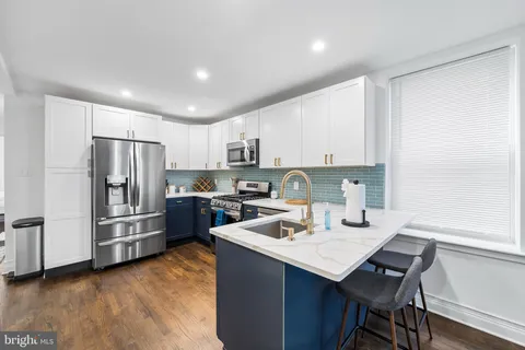 a kitchen with refrigerator cabinets and wooden floor