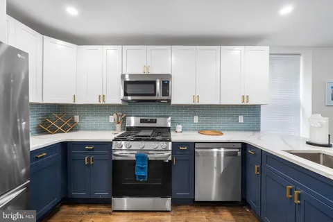 a kitchen with stainless steel appliances a stove a sink and a microwave