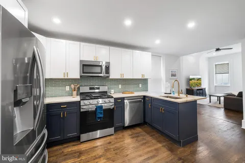 a kitchen with stainless steel appliances granite countertop a stove top oven a sink dishwasher a refrigerator and a microwave