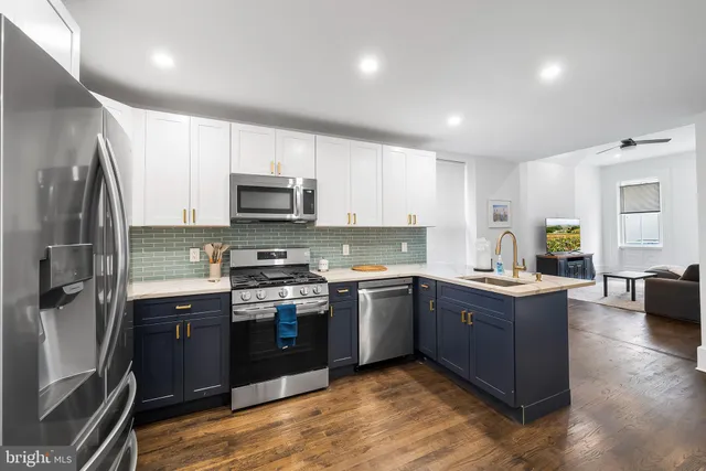 a kitchen with stainless steel appliances granite countertop a stove top oven a sink dishwasher a refrigerator and a microwave