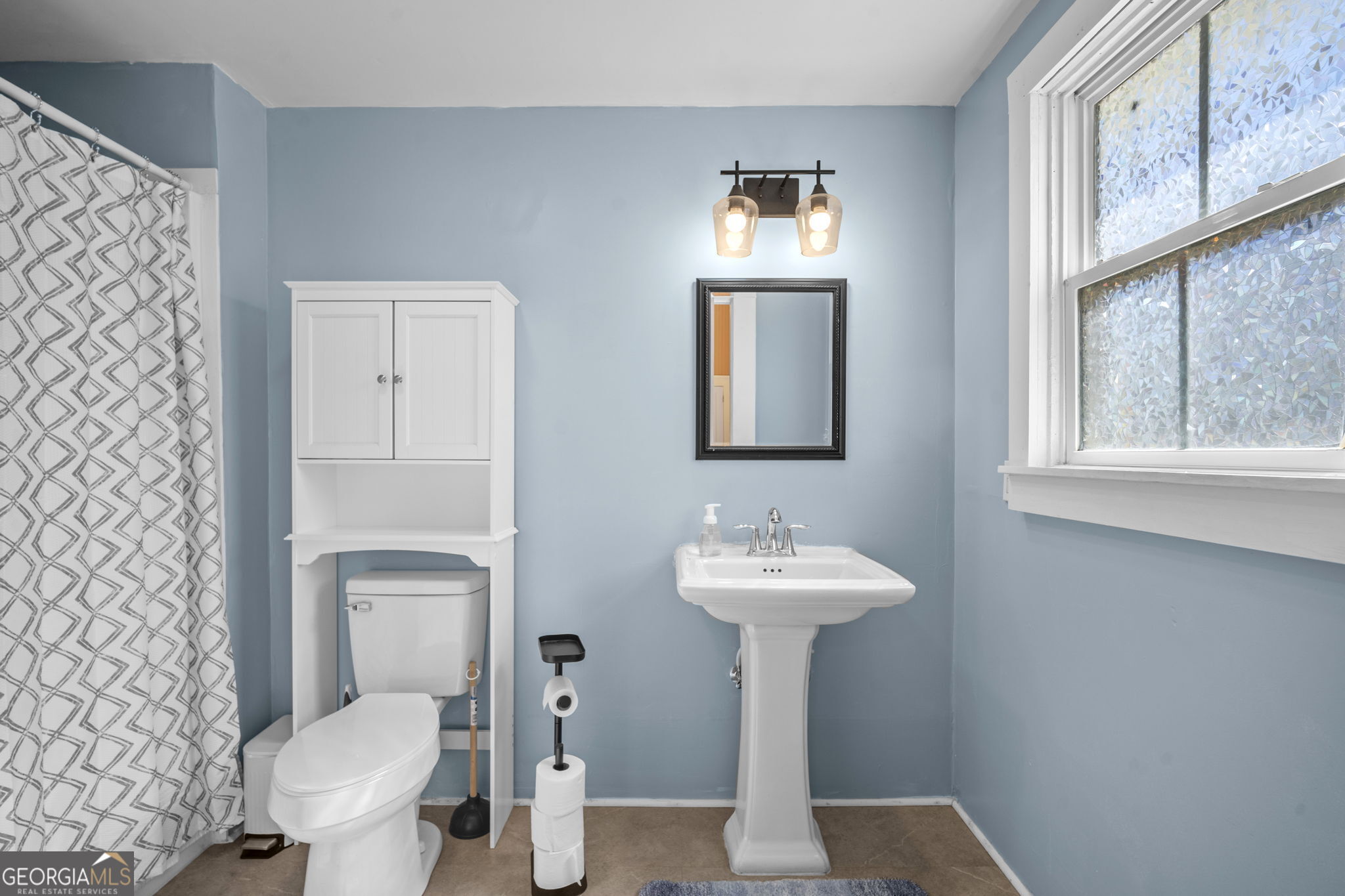 295 South Lewis Street Metter, GA 30439 - Photo 9 of 24 a bathroom with a toilet sink and mirror