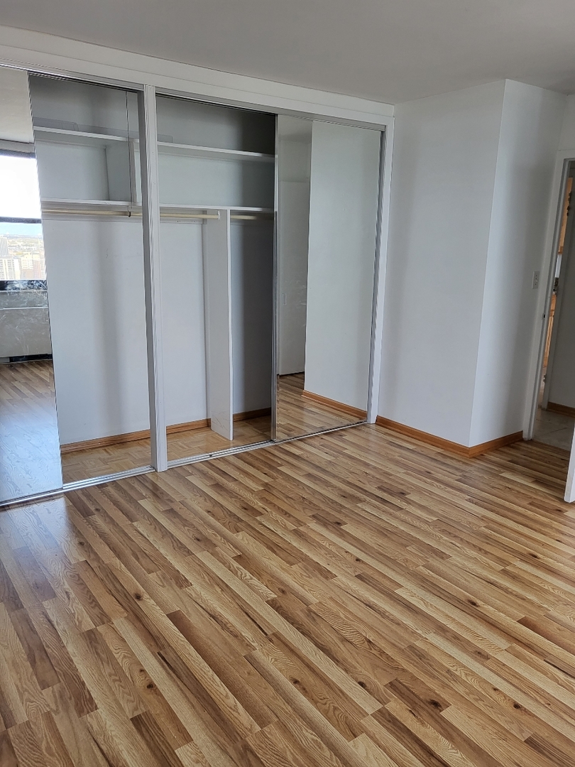 5701 North Sheridan Road, Unit 30B Chicago, IL 60660 - Photo 5 of 9 a view of an empty room with wooden floor and a window