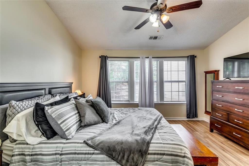 4175 Howell Park Road Duluth, GA 30096 - Photo 14 of 36 a bed sitting in a bedroom next to a window and a chandelier