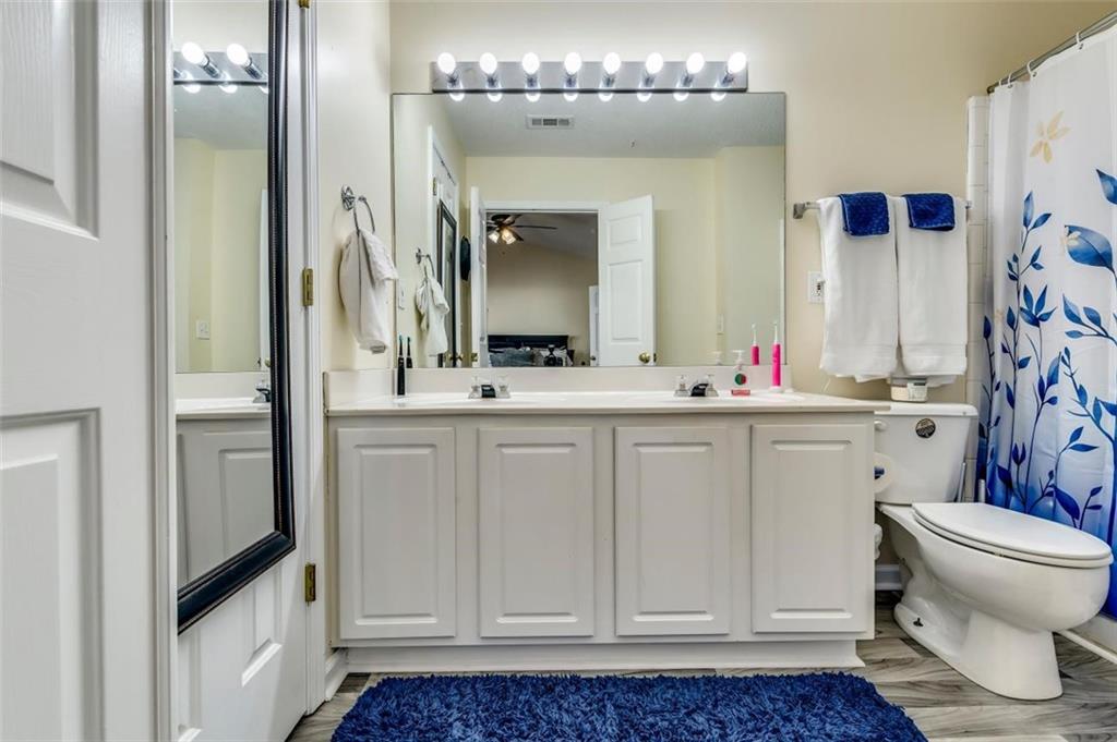 4175 Howell Park Road Duluth, GA 30096 - Photo 17 of 36 a bathroom with a sink vanity toilet and shower