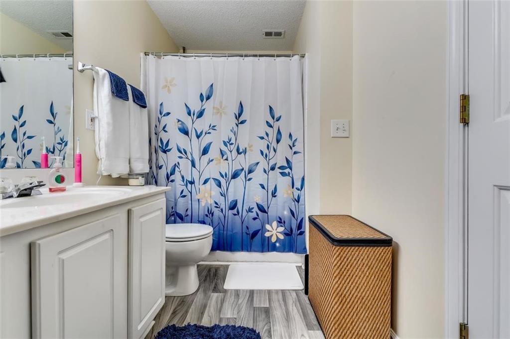 4175 Howell Park Road Duluth, GA 30096 - Photo 18 of 36 a bathroom with a sink toilet and shower curtain
