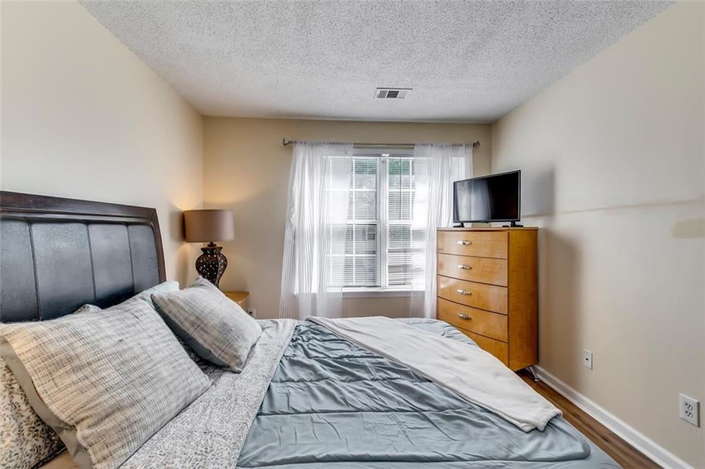 4175 Howell Park Road Duluth, GA 30096 - Photo 23 of 36 a bedroom with a bed and a flat screen tv