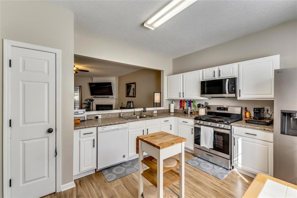 4175 Howell Park Road Duluth, GA 30096 - Photo 5 of 36 a kitchen with white cabinets and stainless steel appliances
