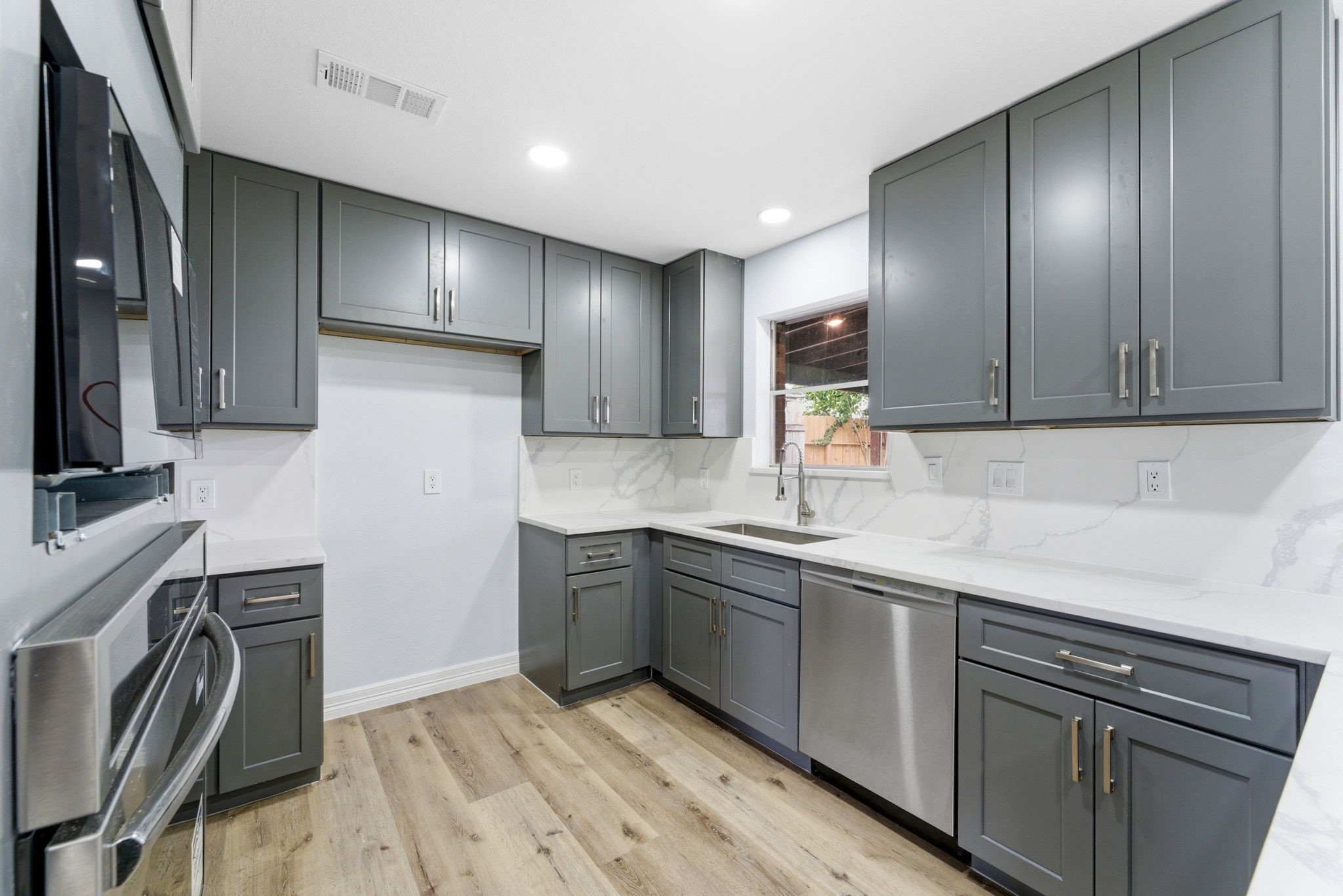 910 Beaver Bend Road Houston, TX 77088 - Photo 17 of 48 Beautifully updated kitchen featuring sleek cabinetry, quartz surfaces, and built-in stainless appliances, designed for both everyday living and effortless entertaining.