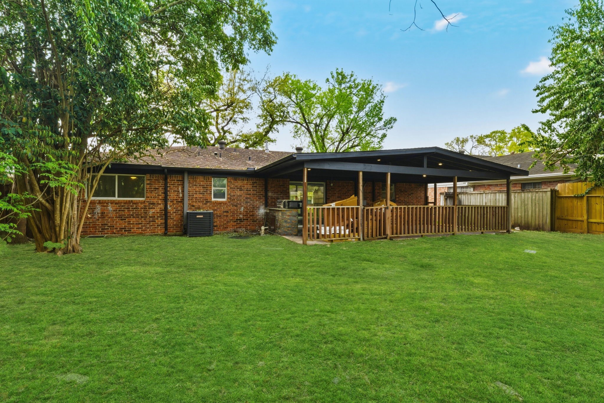 910 Beaver Bend Road Houston, TX 77088 - Photo 29 of 48 Step outside and imagine evenings spent under this spacious covered patio, perfect for weekend BBQs, relaxing with friends, or simply enjoying the peaceful backyard setting.
