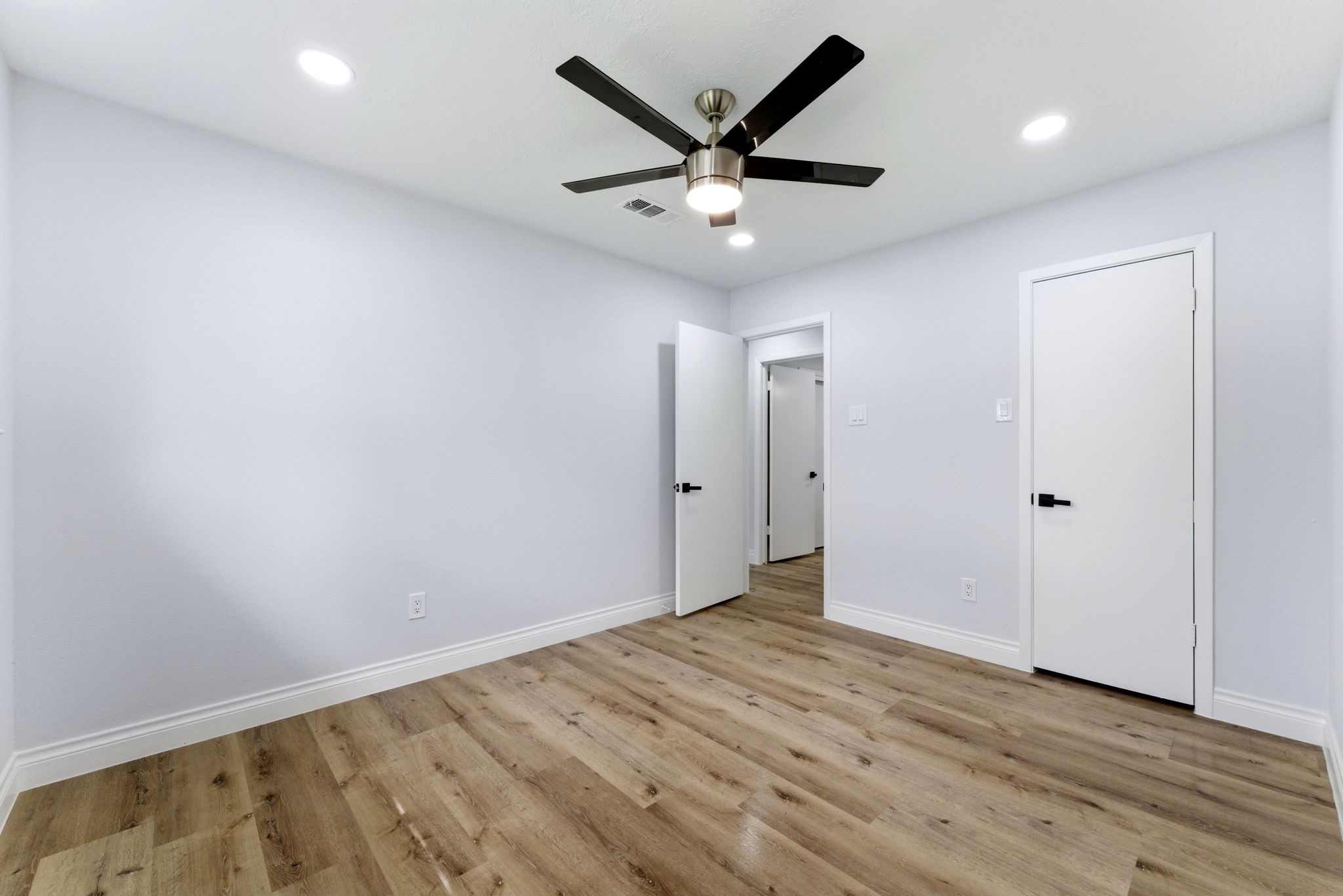 910 Beaver Bend Road Houston, TX 77088 - Photo 46 of 48 Clean lines, warm flooring, and a modern ceiling fan make this bedroom feel both stylish and inviting—ready to become your personal sanctuary.