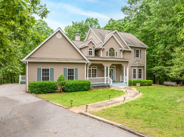 a view of a house with a small yard and wooden floor and fence