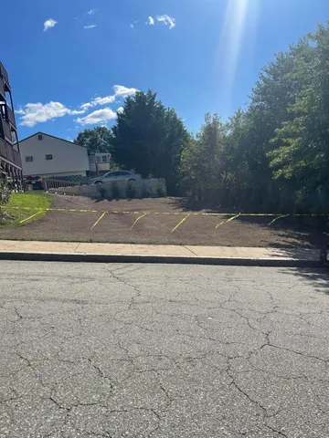 a view of a house with a big yard and a large trees