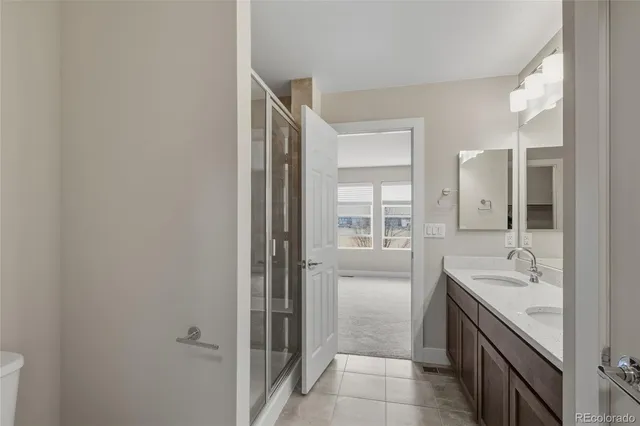 a bathroom with a double vanity sink mirror and shower