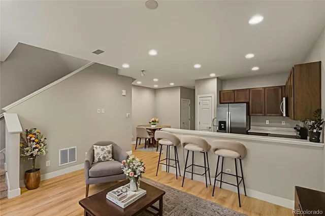 a kitchen with stainless steel appliances granite countertop a refrigerator a sink a stove top oven and a refrigerator