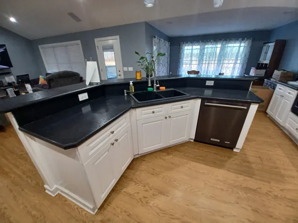 a kitchen with stainless steel appliances granite countertop a sink a stove a counter space and cabinets