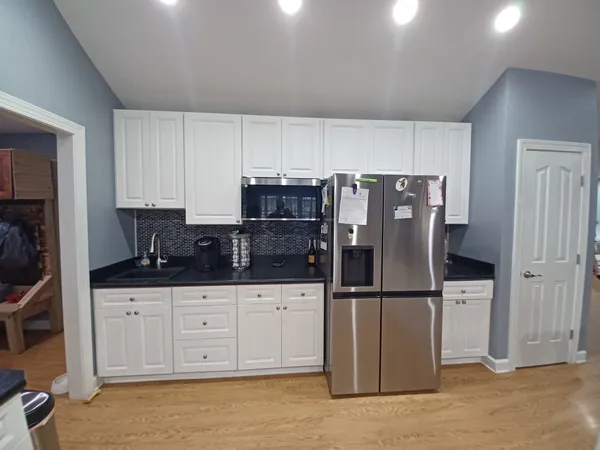 a kitchen with granite countertop a refrigerator and a stove top oven