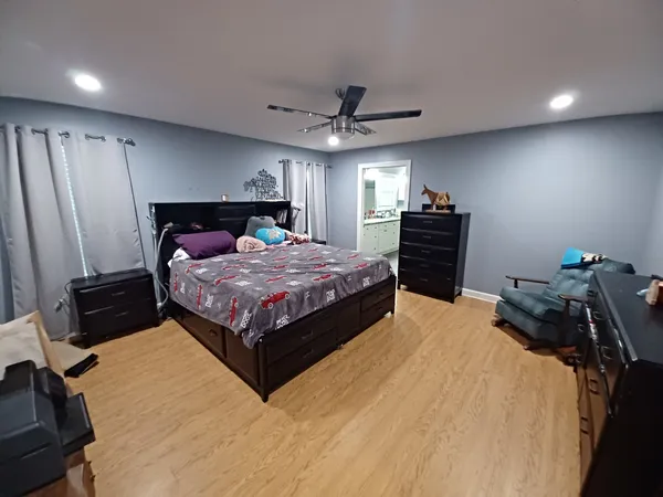 a bedroom with a bed and dresser with window