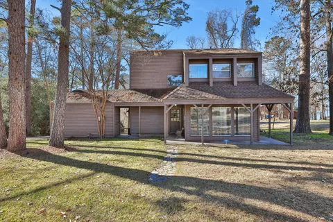 a view of a house with a yard and large tree