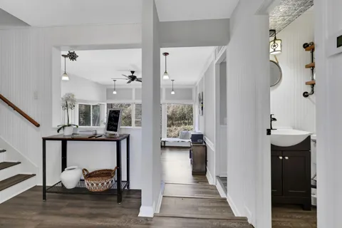 a view of hall way with furniture and wooden floor