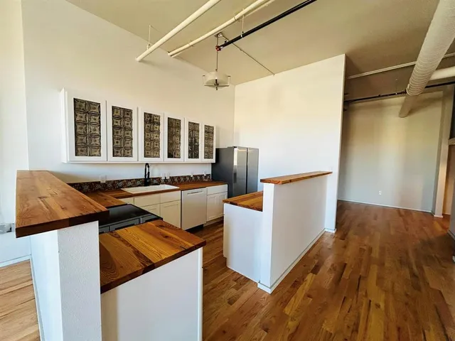 a kitchen view with a sink and wooden floor