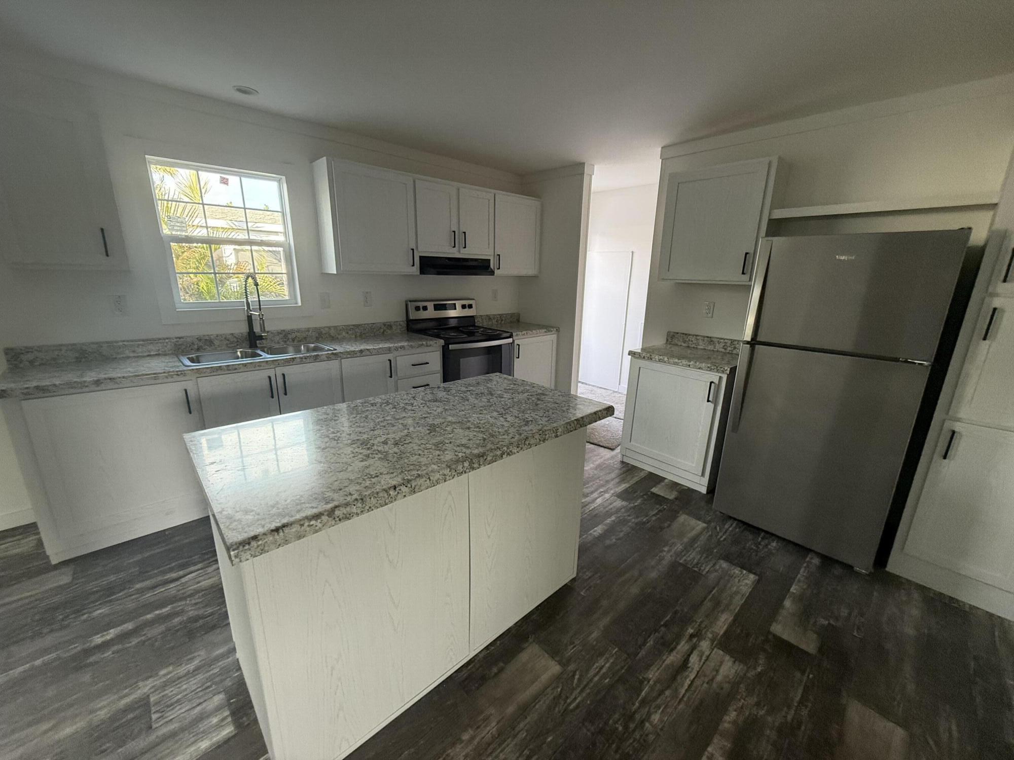 22963 Seaspray Place Boca Raton, FL 33428 - Photo 1 of 10 a kitchen with granite countertop a refrigerator a sink a stove a microwave a sink and dishwasher with wooden floor
