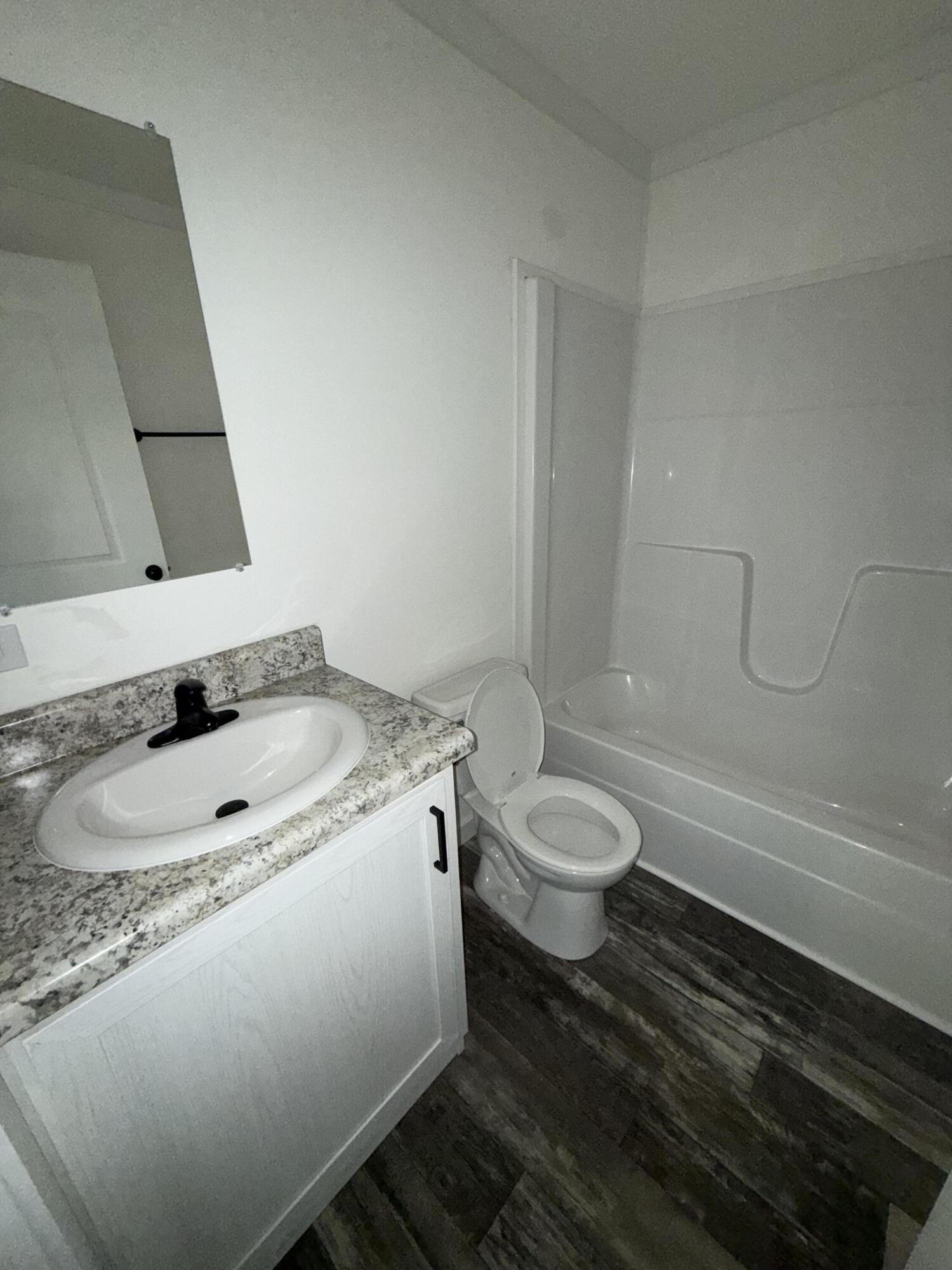 22963 Seaspray Place Boca Raton, FL 33428 - Photo 6 of 10 a bathroom with a granite countertop sink a toilet and bathtub