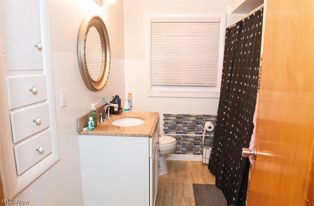 6714 Trenholm Road Youngstown, OH 44512 - Photo 9 of 22 Bathroom featuring wood-type flooring, toilet, and vanity