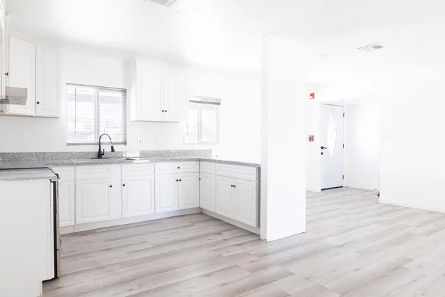 a kitchen with granite countertop white cabinets and white appliances