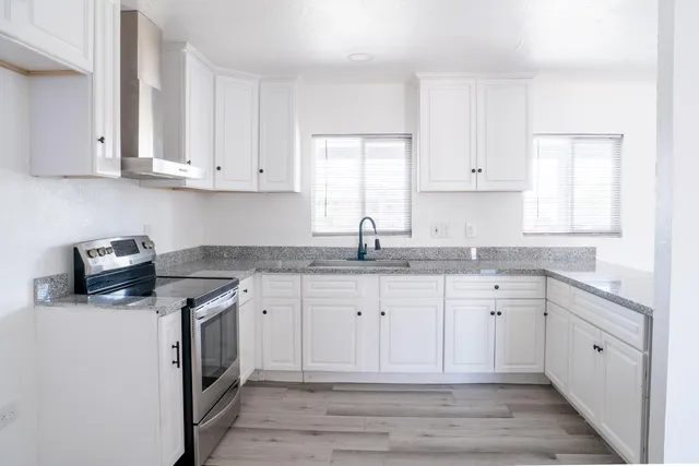 a kitchen with stainless steel appliances granite countertop a sink stove and cabinets