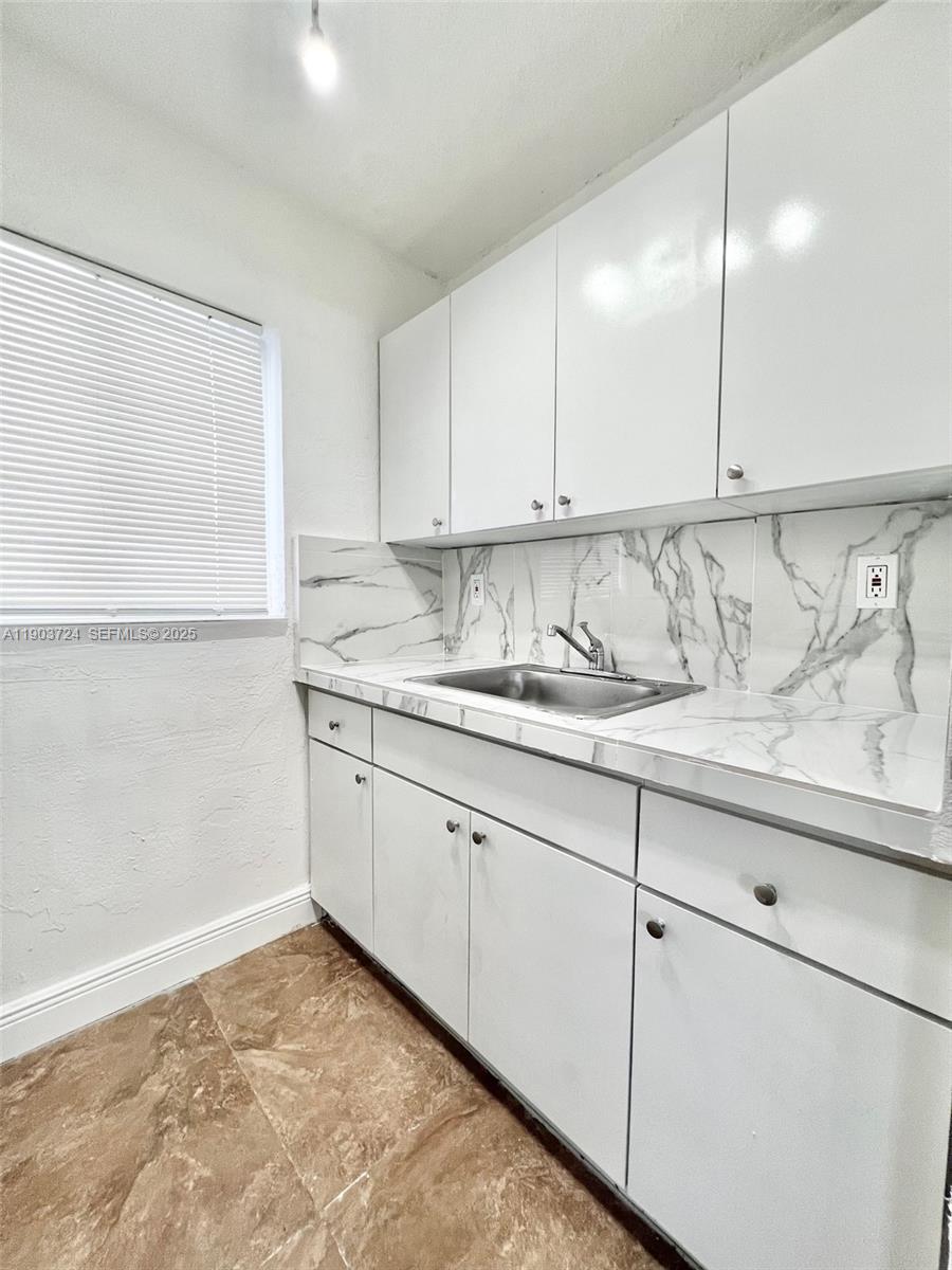 10 Northwest 77th Street, Unit 10 Miami, FL 33150 - Photo 4 of 12 a kitchen with a sink cabinets and window