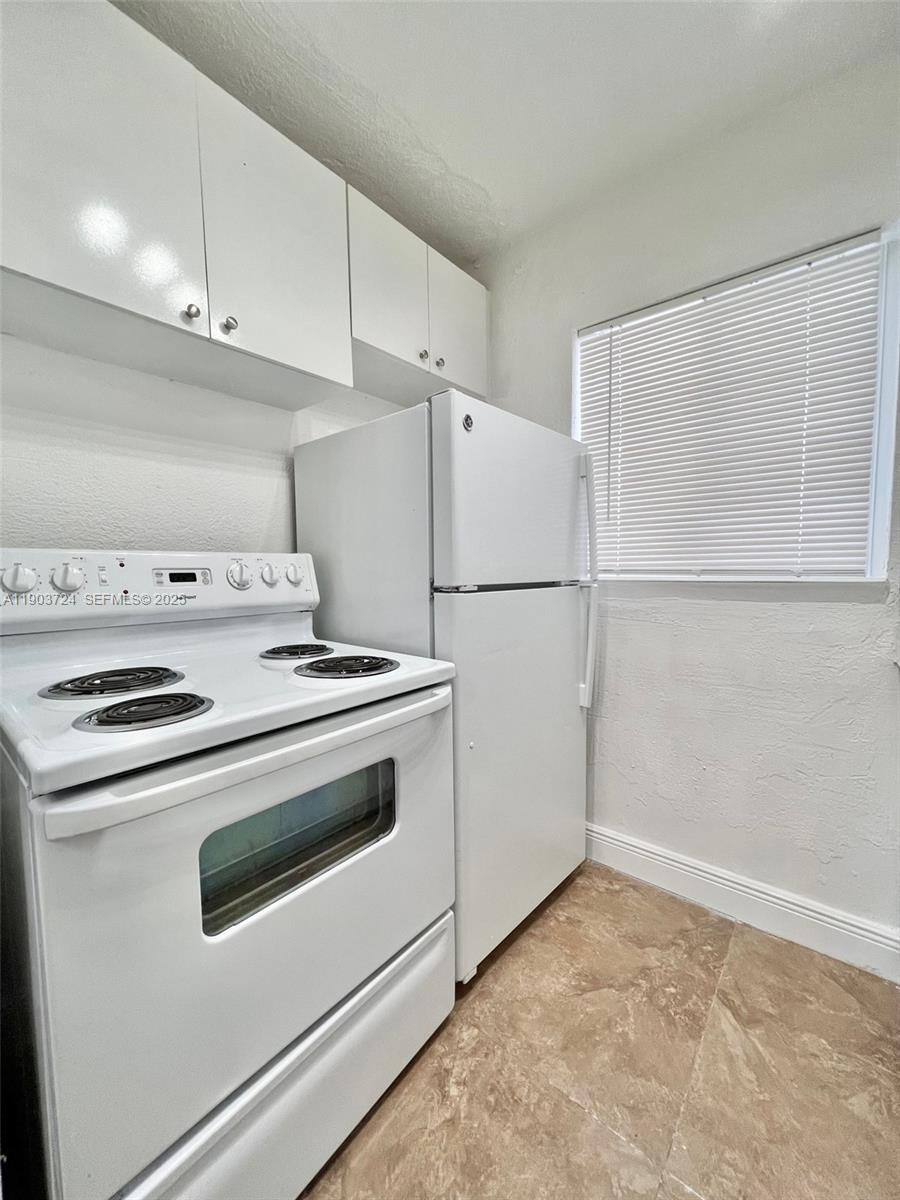 10 Northwest 77th Street, Unit 10 Miami, FL 33150 - Photo 7 of 12 a white stove top oven sitting inside of a kitchen