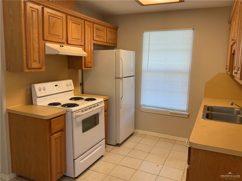 808 West Bronze Avenue, Unit B Pharr, TX 78577 - Photo 14 of 20 a kitchen with a stove top oven a sink and a refrigerator