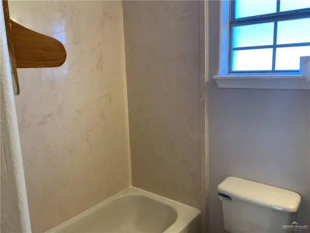 a white toilet sitting next to a window