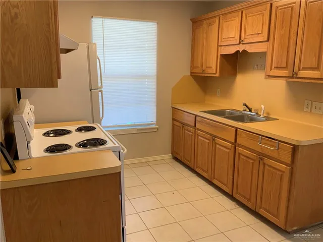 a kitchen with a sink a stove and a refrigerator