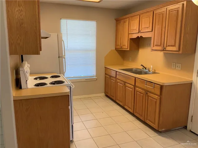 a kitchen with stainless steel appliances a stove a sink and a refrigerator