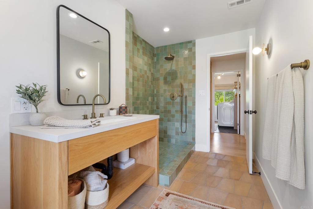 710 Edelweiss Lane Encinitas, CA 92024 - Photo 14 of 32 a bathroom with a sink a mirror and a shower