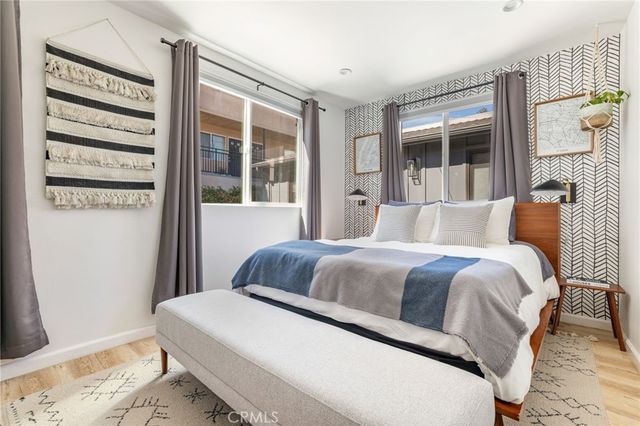 a living room with furniture a flat screen tv and a wooden floor