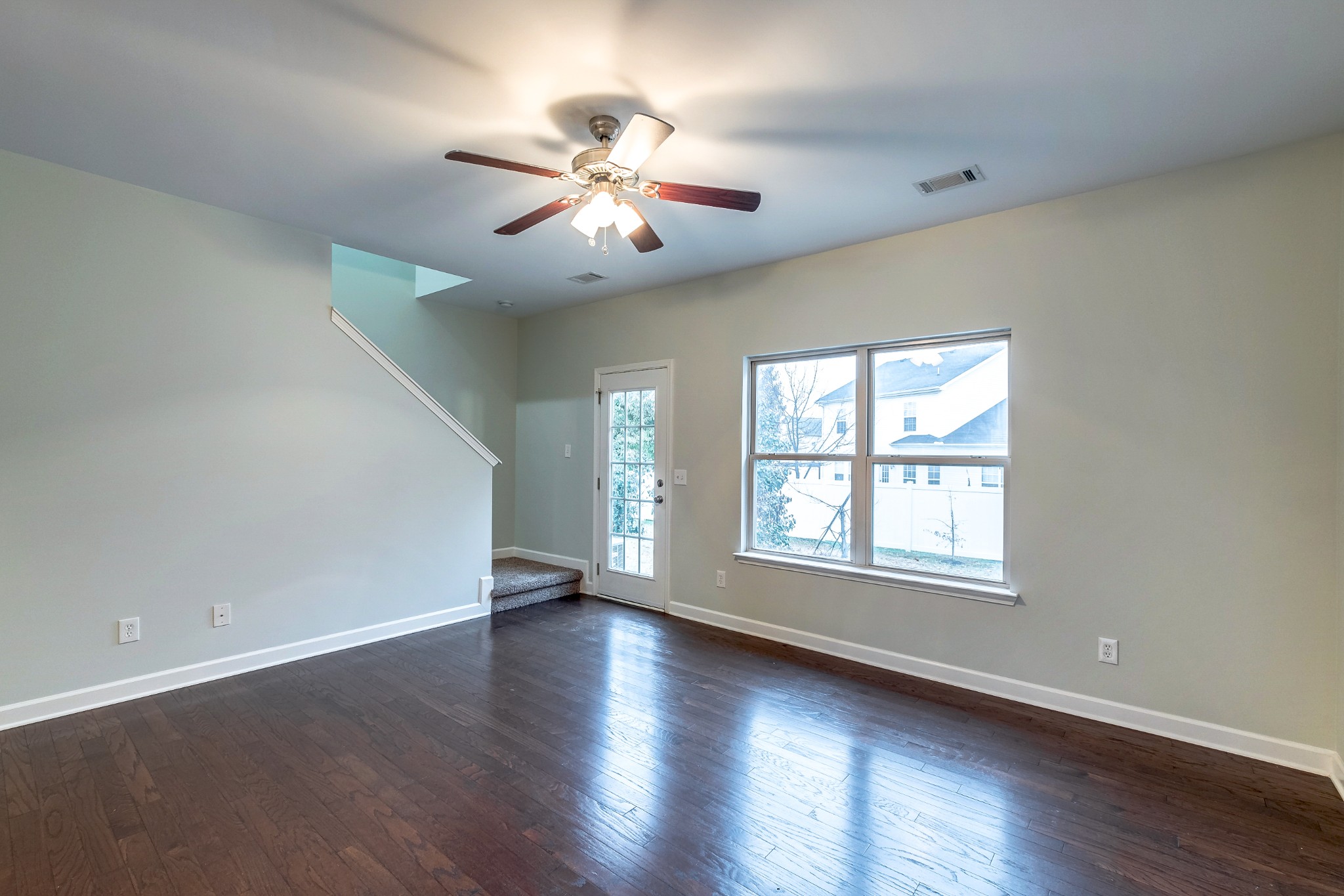5441 Perlou Lane Murfreesboro, TN 37128 - Photo 9 of 35 an empty room with wooden floor chandelier fan and windows