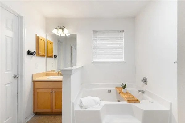 a bathroom with a tub sink and mirror