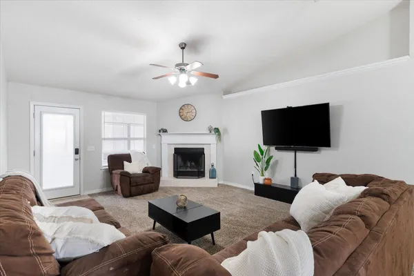 a living room with furniture a fireplace and a flat screen tv