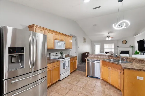 a kitchen with stainless steel appliances granite countertop a stove and a refrigerator
