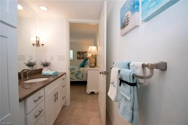 a en suite bathroom with a granite countertop sink and a mirror