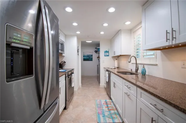 a kitchen with stainless steel appliances granite countertop a refrigerator and a sink