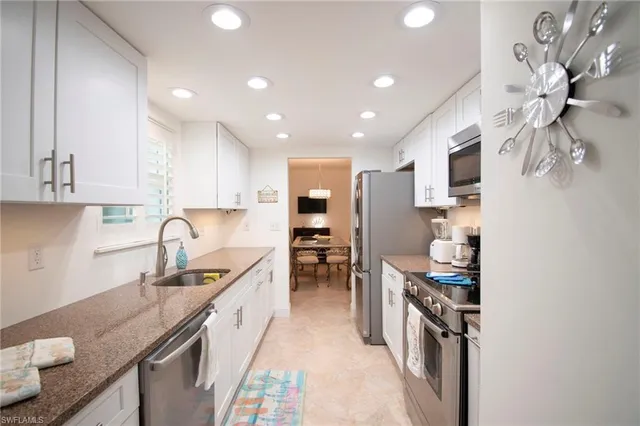 a kitchen with granite countertop a sink stove and cabinets