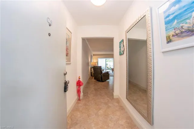 a view of a hallway with wooden floor and furniture