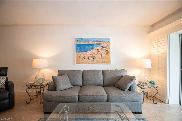 a living room with furniture a couch and a large window