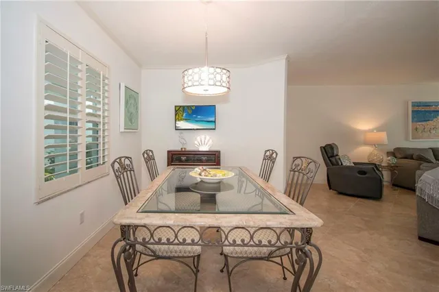 a view of a dining room with furniture a chandelier and a window